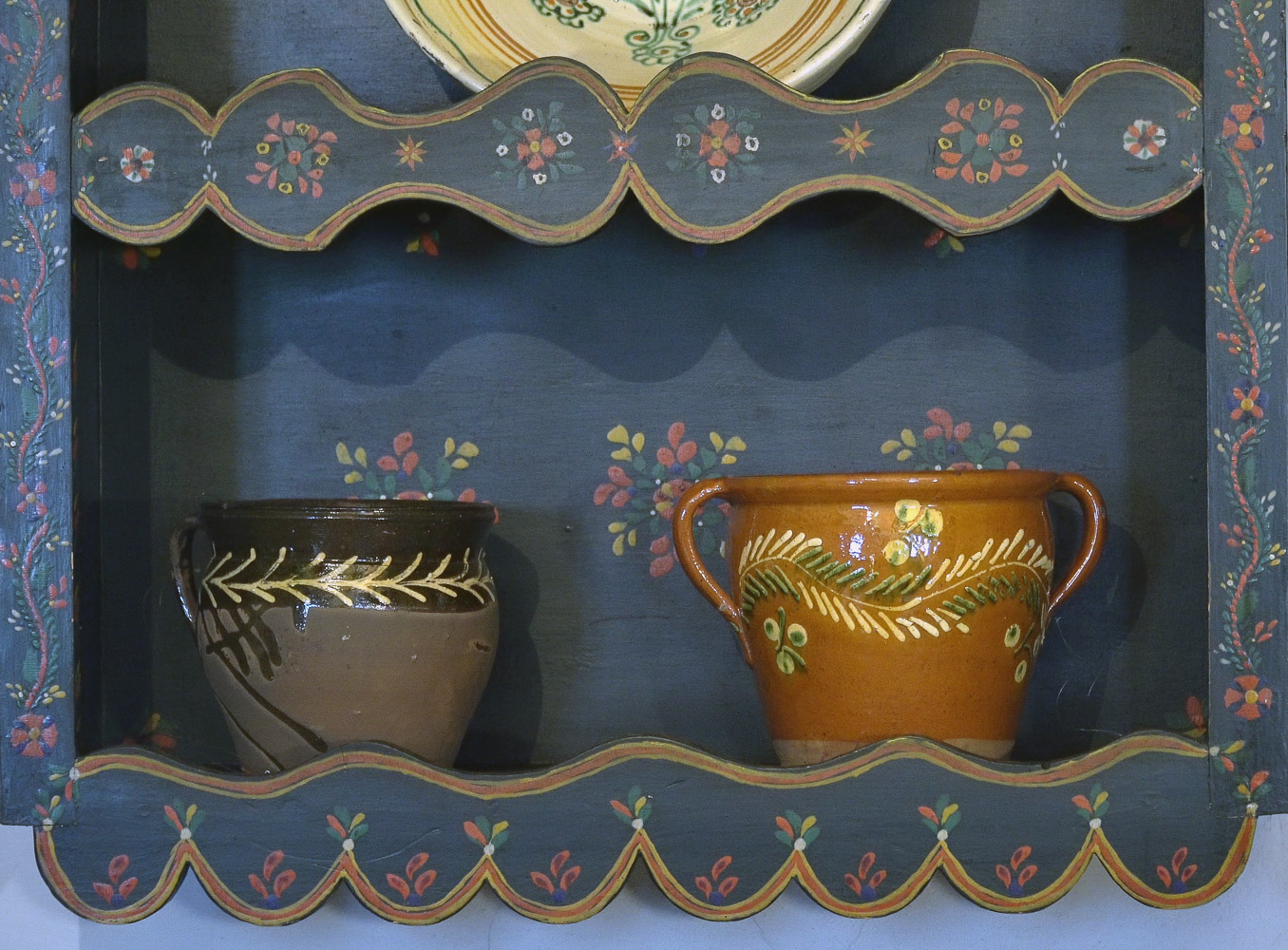dwa ręcznie zdobione garnki na półce
