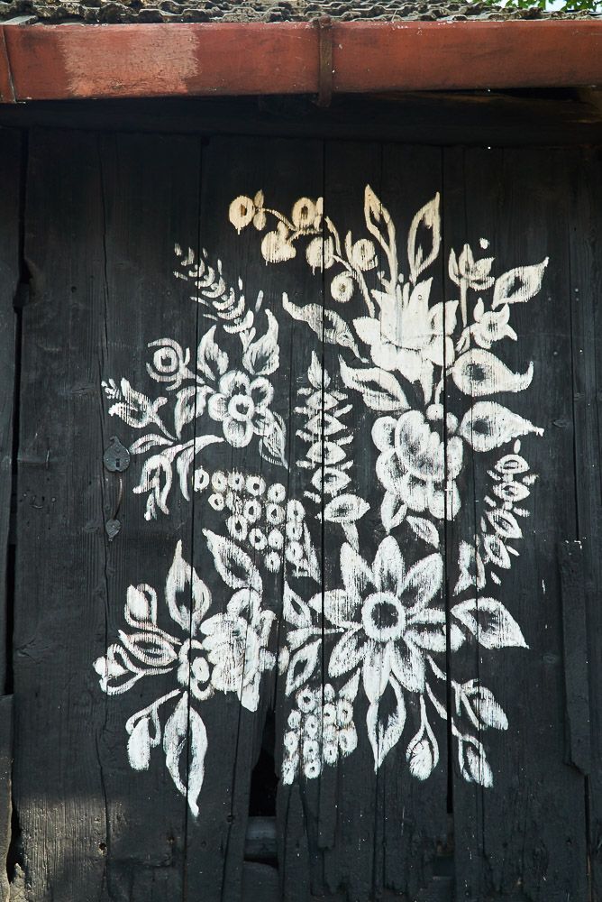 biały motyw kwiatowy na czarnych drzwiach